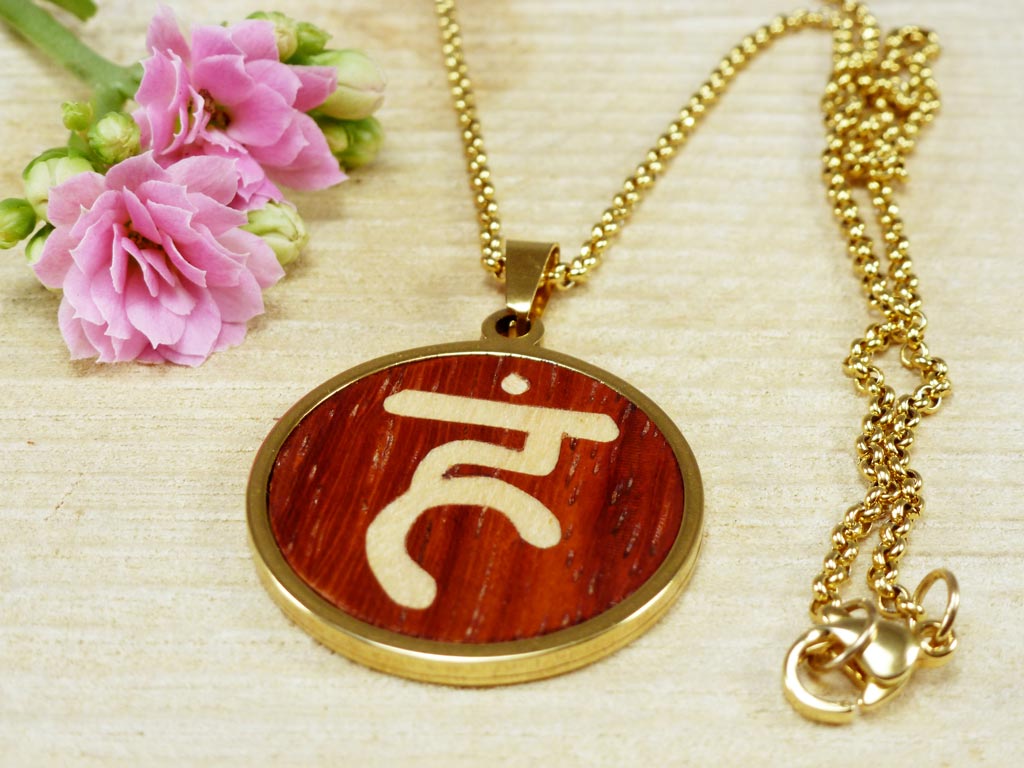Colgante artesanal de madera y acero con el símbolo del chakra Vishuddha, conocido también como el chakra de la garganta. Diseño espiritual y minimalista que simboliza la comunicación y la expresión, ideal para prácticas de meditación y bienestar