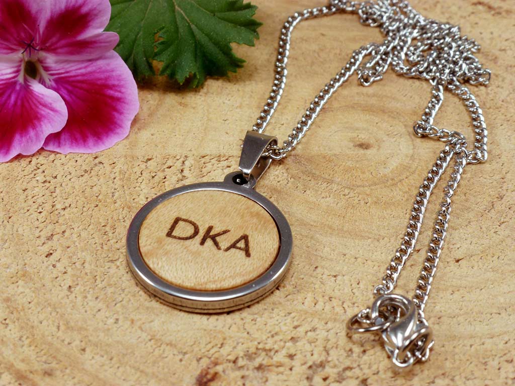 Colgante redondo y pequeño de madera y acero personalizados con el grabado de tres iniciales. Joyería hecha a mano personalizada para mujeres.