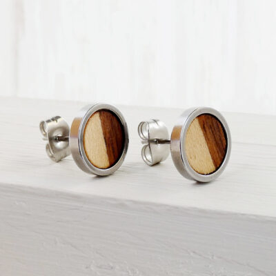 Close-up of handmade earrings with walnut and sycamore wood and stainless steel base