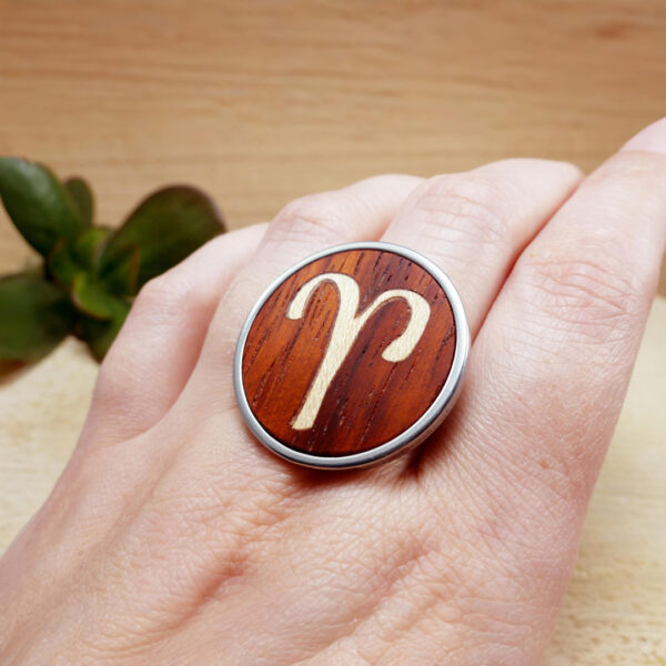 Adjustable Aries zodiac ring on hand, made from wood and stainless steel