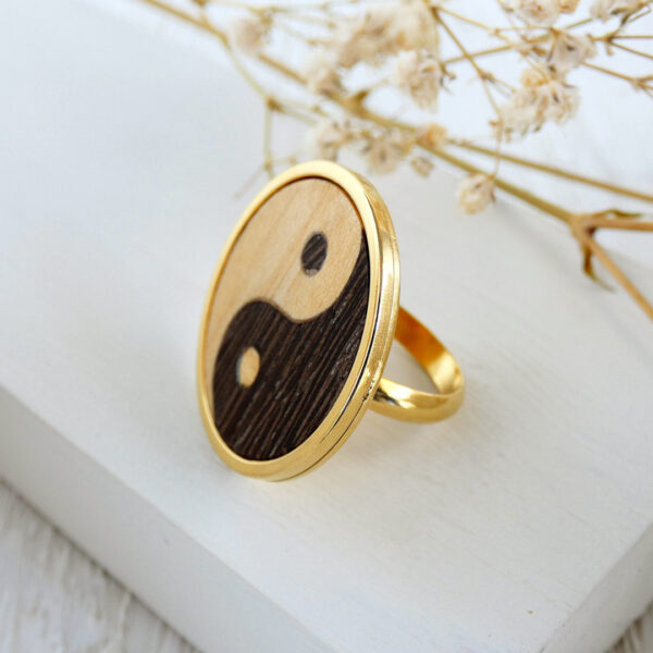Side profile of a wooden yin yang ring with marquetry and metal band