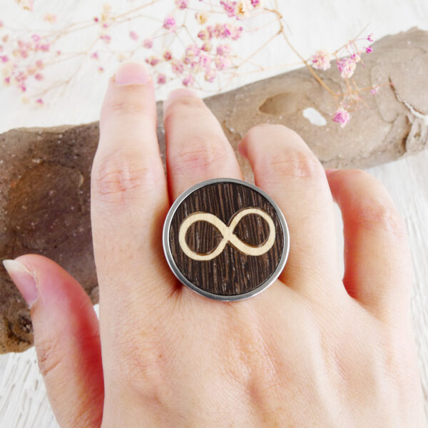 Infinity ring for her in stainless steel with wood inlay shown on hand