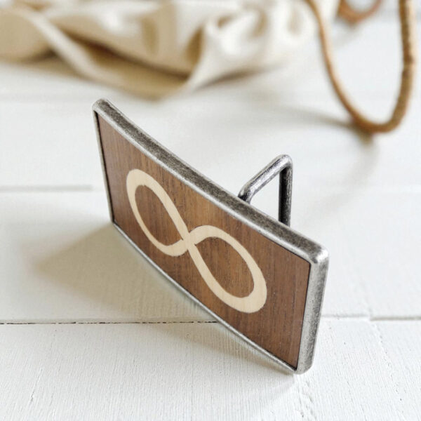 Close-up of belt buckle with wooden infinity symbol