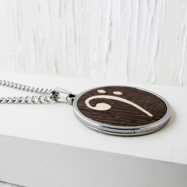 Round music pendant necklace with wooden bass clef and steel frame