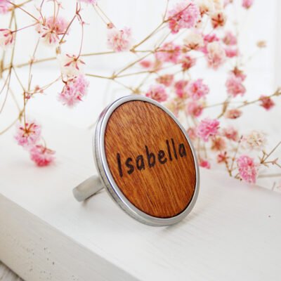 Personalized name ring with engraved natural wood and stainless steel base.