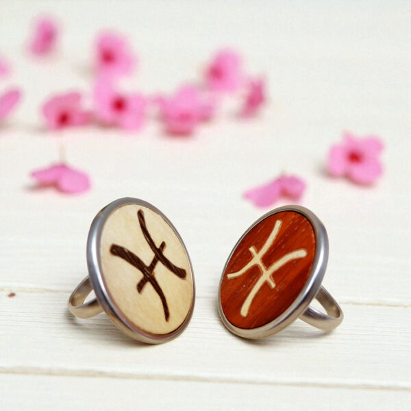 Pair of Pisces rings with different wood tones and stainless steel base