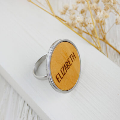 Ring with name engraved in natural wood and mounted on a stainless steel adjustable band.