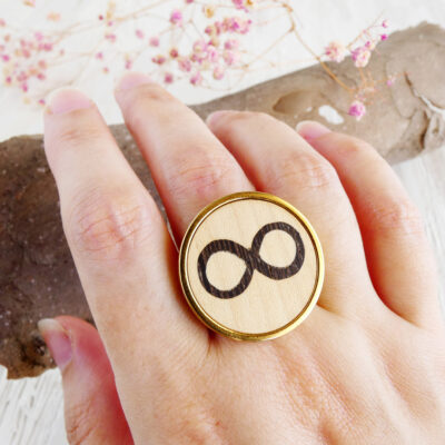 Women’s infinity ring with gold-plated finish and wood inlay on hand
