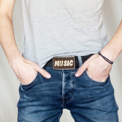 Music-themed belt buckle worn by a man – perfect for musicians