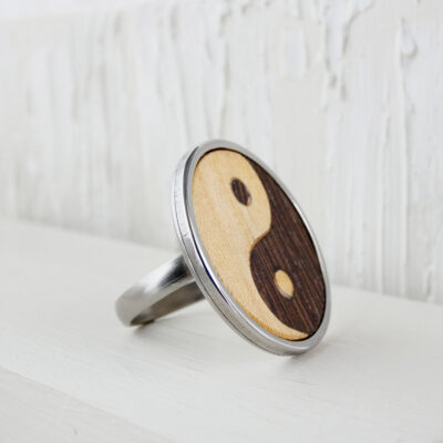Close-up of a handmade wooden yin yang ring with wenge and sycamore wood