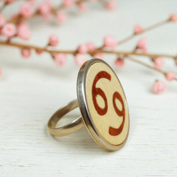 Wooden zodiac jewelry with Cancer symbol inlay and steel ring base